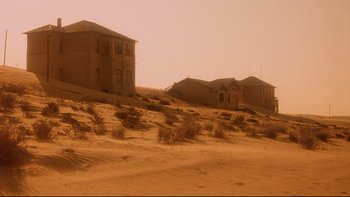 Movie still from “Dust Devil” (1992), directed by Richard Stanley – An old abandoned house in the middle of the desert; Extreme Wide shot, Low angle