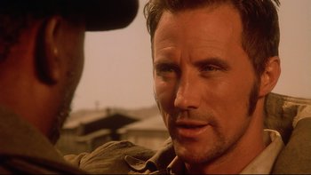 Movie still from “Dust Devil” (1992), directed by Richard Stanley – A person with a hat; Close Up shot, Over the shoulder angle