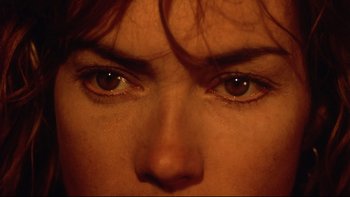 Movie still from “Dust Devil” (1992), directed by Richard Stanley – A person's eyes with red hair; Extreme Close Up shot, Overhead angle