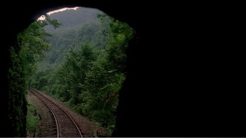 Movie still from “Dust in the Wind” (1986), directed by Hsiao-Hsien Hou – A view of a train track with trees in the background; Extreme Wide shot, High angle