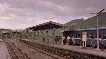 Movie still from “Dust in the Wind” (1986), directed by Hsiao-Hsien Hou – People are standing at a train station waiting for a train to arrive; Extreme Wide shot, High angle