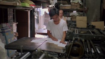 Movie still from “Dust in the Wind” (1986), directed by Hsiao-Hsien Hou – A man working in an industrial setting in a factory; Medium shot, High angle