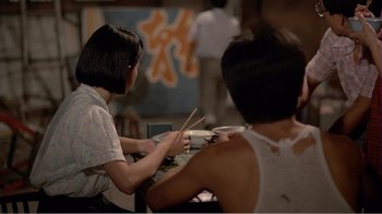 Movie still from “Dust in the Wind” (1986), directed by Hsiao-Hsien Hou – Two people sitting at a table holding chopsticks; Medium shot, Over the shoulder angle