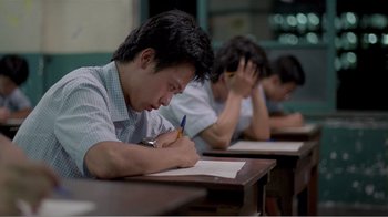 Movie still from “Dust in the Wind” (1986), directed by Hsiao-Hsien Hou – A group of people sitting at a desk writing on papers; Close Up shot, High angle