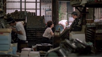 Movie still from “Dust in the Wind” (1986), directed by Hsiao-Hsien Hou – A group of people working in a printing shop; Wide shot, High angle