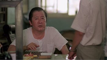 Movie still from “Dust in the Wind” (1986), directed by Hsiao-Hsien Hou – A man sitting at a table with food in front of him; Close Up shot, Over the shoulder angle