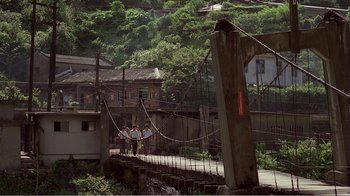 Movie still from “Dust in the Wind” (1986), directed by Hsiao-Hsien Hou – A group of people walking across a bridge over a river; Extreme Wide shot, High angle
