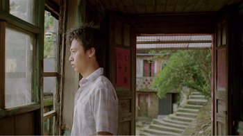 Movie still from “Dust in the Wind” (1986), directed by Hsiao-Hsien Hou – A man standing in front of an open window; Medium shot, Low angle