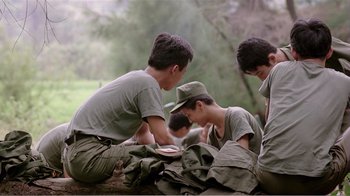 Movie still from “Dust in the Wind” (1986), directed by Hsiao-Hsien Hou – A group of young men sitting next to each other on the ground; Medium shot, High angle