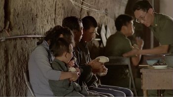 Movie still from “Dust in the Wind” (1986), directed by Hsiao-Hsien Hou – A group of people sitting next to each other holding game controllers; Medium shot, Over the shoulder angle