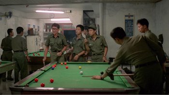Movie still from “Dust in the Wind” (1986), directed by Hsiao-Hsien Hou – A group of men playing a game of billiards; Medium shot, High angle