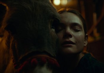 Movie still from “EO” (2022), directed by Jerzy Skolimowski – A woman with her eyes closed looking at a stuffed animal; Close Up shot, High angle