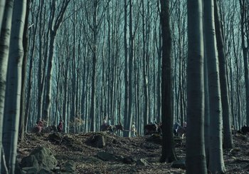 Movie still from “EO” (2022), directed by Jerzy Skolimowski – A group of people standing in the middle of a forest; Extreme Wide shot, High angle