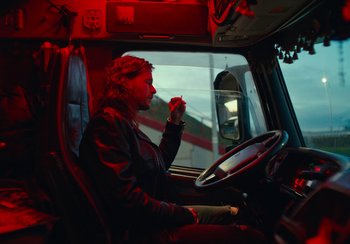Movie still from “EO” (2022), directed by Jerzy Skolimowski – A woman sitting in the driver's seat of a semi truck; Medium shot, Low angle