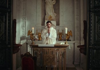 Movie still from “EO” (2022), directed by Jerzy Skolimowski – A man in a white robe standing in front of an altar; Wide shot, Low angle