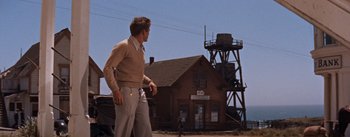 Movie still from “East of Eden” (1955), directed by Elia Kazan – A man walking in front of an old building; Wide shot, Low angle