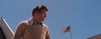 Movie still from “East of Eden” (1955), directed by Elia Kazan – A young man standing in front of an american flag; Medium shot, Low angle