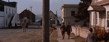 Movie still from “East of Eden” (1955), directed by Elia Kazan – Two men walking down the sidewalk of a street; Extreme Wide shot, High angle