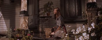 Movie still from “East of Eden” (1955), directed by Elia Kazan – A woman sitting on the ground in front of a house; Wide shot, Low angle