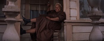 Movie still from “East of Eden” (1955), directed by Elia Kazan – An older woman sitting on a chair holding a cell phone; Wide shot, Low angle