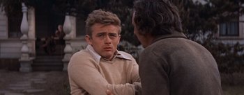 Movie still from “East of Eden” (1955), directed by Elia Kazan – A man in a beige sweater talking to another man in a brown jacket; Close Up shot, Over the shoulder angle
