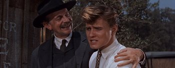 Movie still from “East of Eden” (1955), directed by Elia Kazan – An older man and a young man in a suit and tie next to each other; Close Up shot, Over the shoulder angle