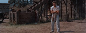 Movie still from “East of Eden” (1955), directed by Elia Kazan – A man standing on a dirt road with his arms crossed; Medium shot, Low angle