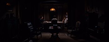Movie still from “East of Eden” (1955), directed by Elia Kazan – A group of people sitting at a table in a dark room; Wide shot, High angle