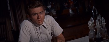 Movie still from “East of Eden” (1955), directed by Elia Kazan – A man sitting at a table in front of a window; Close Up shot, Over the shoulder angle