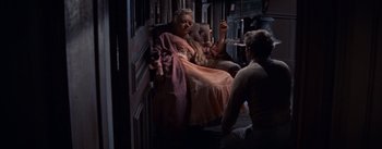 Movie still from “East of Eden” (1955), directed by Elia Kazan – A woman sitting in a chair next to a man; Wide shot, High angle