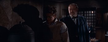 Movie still from “East of Eden” (1955), directed by Elia Kazan – A man in a suit and tie standing next to another man in a suit and tie; Medium shot, Over the shoulder angle