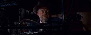 Movie still from “East of Eden” (1955), directed by Elia Kazan – An older man wearing a suit and a hat sitting in a car; Close Up shot, Over the shoulder angle