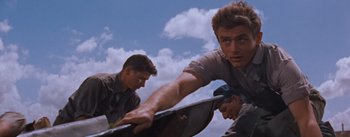 Movie still from “East of Eden” (1955), directed by Elia Kazan – A group of young men standing next to each other on skateboards; Medium shot, Low angle