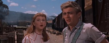 Movie still from “East of Eden” (1955), directed by Elia Kazan – A man and a woman standing next to each other in front of train tracks; Medium shot, Low angle