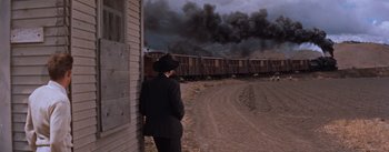Movie still from “East of Eden” (1955), directed by Elia Kazan – A man standing in front of a train on the tracks; Wide shot, Over the shoulder angle