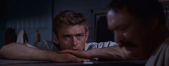 Movie still from “East of Eden” (1955), directed by Elia Kazan – A man sitting at a table with his hand on his chin; Close Up shot, Over the shoulder angle