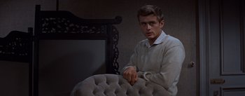 Movie still from “East of Eden” (1955), directed by Elia Kazan – A man sitting on a chair in a room; Medium shot, Over the shoulder angle