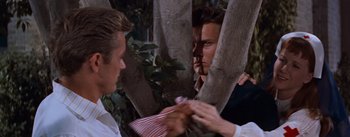 Movie still from “East of Eden” (1955), directed by Elia Kazan – A man holding a red and white striped paper bag in front of a mirror; Close Up shot, Over the shoulder angle