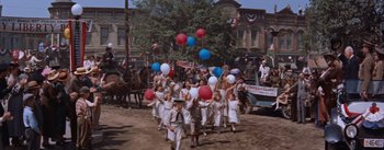 Movie still from “East of Eden” (1955), directed by Elia Kazan – A group of young children in a parade holding red , white , and blue balloons; Wide shot, High angle