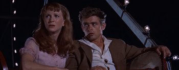 Movie still from “East of Eden” (1955), directed by Elia Kazan – A man and a woman sitting next to each other in front of a projector screen; Close Up shot, Low angle