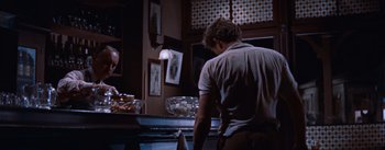 Movie still from “East of Eden” (1955), directed by Elia Kazan – A man standing in front of an oven in a kitchen; Medium shot, Over the shoulder angle