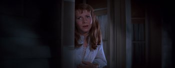 Movie still from “East of Eden” (1955), directed by Elia Kazan – A woman in a white shirt is standing in front of a window; Close Up shot, Over the shoulder angle
