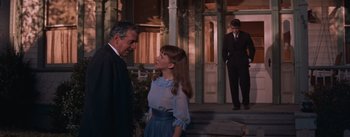 Movie still from “East of Eden” (1955), directed by Elia Kazan – A man and a woman standing next to each other on a porch; Medium shot, Over the shoulder angle