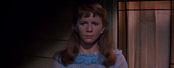 Movie still from “East of Eden” (1955), directed by Elia Kazan – A woman with long brown hair wearing a blue and white striped dress; Close Up shot, High angle