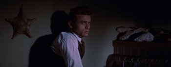 Movie still from “East of Eden” (1955), directed by Elia Kazan – A man in a suit and tie looking at the camera; Close Up shot, Low angle