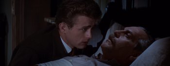 Movie still from “East of Eden” (1955), directed by Elia Kazan – A man in a business suit looking at another man in a dress shirt and tie; Close Up shot, Over the shoulder angle
