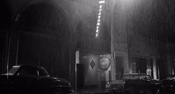 Movie still from “Ed Wood” (1994), directed by Tim Burton – A black and white photo of a building in the pouring rain; Extreme Wide shot, High angle