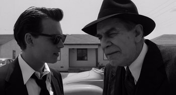 Movie still from “Ed Wood” (1994), directed by Tim Burton – A man in a hat and a man in a suit talking to each other; Close Up shot, Over the shoulder angle