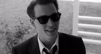 Movie still from “Ed Wood” (1994), directed by Tim Burton – A young man wearing a suit and sunglasses; Close Up shot, High angle
