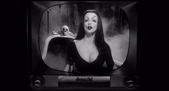 Movie still from “Ed Wood” (1994), directed by Tim Burton – A black and white photo of a woman with a skull on her shoulder; Medium shot, Low angle